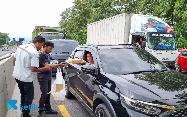 Foto Relawan Nahdliyin membagikan nasi kotak untuk pengendara tol yang terjebak macet. (Foto: Millah Irodah/Ketik.co.id)