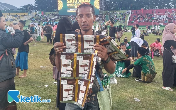 Foto Ahmad pedagang tikar menunjukkan barang dagangannya. ( Husni Habib/Ketik.co.id)