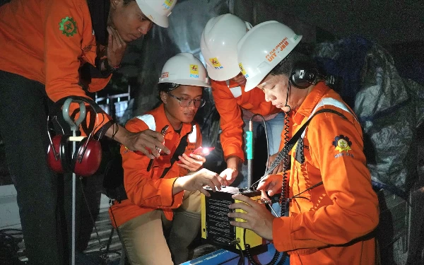 Foto Petugas PLN sedang memperbaiki transmisi untuk pasokan listrik Pulau Madura. ( Foto : Humas Pemprov Jatim)