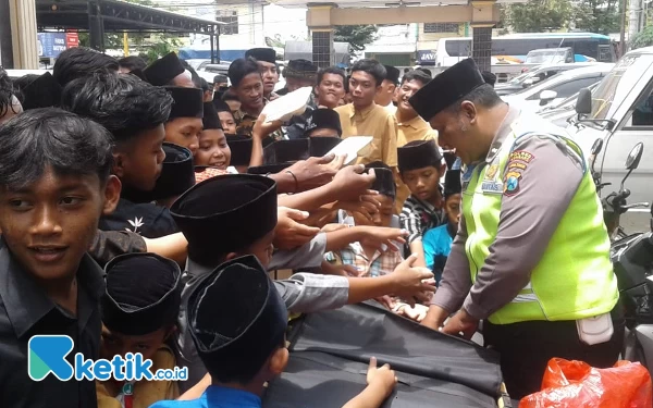 Foto Tim Polres Jombang berbagi nasi bungkus dengan masyarakat. (Foto: Samsul/Ketik.co.id)