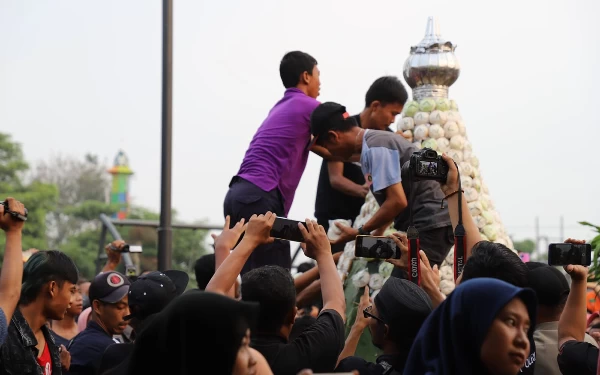 Foto Masyarakat berebut tumpeng apem pada acara megengan di alun-alun Jombang. (Foto: Humas Pemkab Jombang)