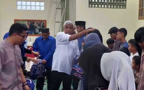 Foto Ketua DPC Demokrat Kab Bandung, Saeful Bachri, menyerahkan santunan kepada anak yatim di Kec Ciparay, Kab Bandung, Jumat (15/4/23). (Foto: Iwa/Ketik.co.id)