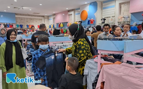 Foto Ibu Kepala Desa tengah memilihkan baju lebaran untuk anak yatim piatu di Jember Roxy Square, Sabtu (15/4/2023) (Foto: Fenna/Ketik.co.id)