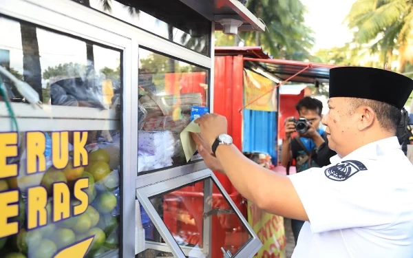 Foto Bupati Jember Hendy Siswanto menempelkan stiker barcode layanan internet gratis di area Alun-alun Jember, Kamis (20/4/2023) (Foto: Diskominfo Jember)