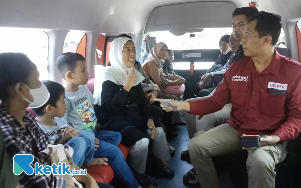 Foto Helper Irawan, sedang memberikan tiket Wira Wiri kepada penumpang
(Foto: Kuncoro S / ketik.co.id)