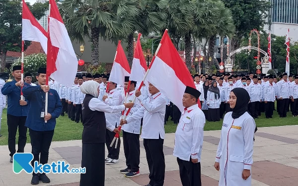 Foto Khofifah secara simbolis memberikan bendera merah putih kepada perwakilan petugas haji Indonesia, Kamis (11/5/2023). (Foto: Husni Habib/Ketik.co.id)