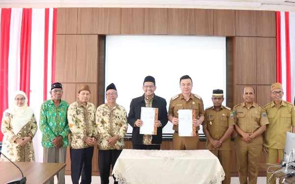 Foto Bupati Kaimana Freddy Thie  bersama Rektor IAIN Kudus menunjukkan berkas MoU yang baru ditandatangani keduanya.  (Foto: Humas Pemkab Kaimana)