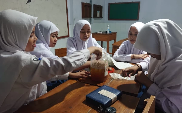 Foto Proses pengolahan limbah dapur menjadi eco enzym oleh siswi SMP Unggulan Annur Hidayatullah.