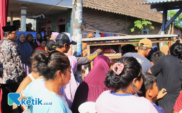 Foto Gus Muhdlor (kiri) berada di dekat emak-emak dan anak-anak yang sedang asyik makan bakso di pinggir sungai Desa Klurak, Kecamatan Candi. (foto: Fathur Roziq/Ketik.co.id)