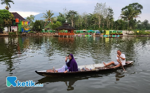 Foto Sepasang nenek kakek yang sedang berduan menikmati susur perahu di danau Cemerlang Asri.