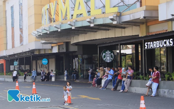 Foto Pengunjung Suncity Mall menunggu pintu kaca mal buka untuk jalan-jalan bersama keluarga saat liburan Idul Adha. (Foto: Fathur Roziq/Ketik.co.id)