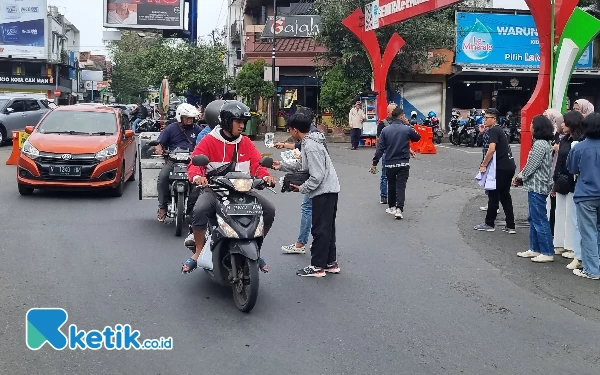 Foto Pengendara motor dibagi stiker Gus Muhaimin oleh relawan.