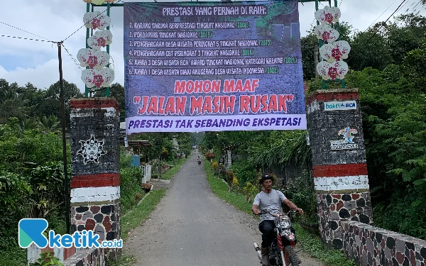 Foto Gapura masuk Jalan Nanas, Desa Semen, Kecamatan Gandusari yang dipasangi spanduk protes warga. Kamis (5/7/2023). (Foto: Favan/Ketik.co.id)