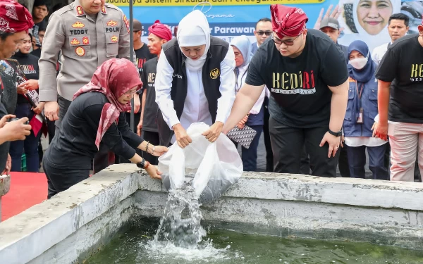 Foto Gubernur Khofifah menebarkan benih ikan lele.(Foto: Humas Pemprov Jatim)