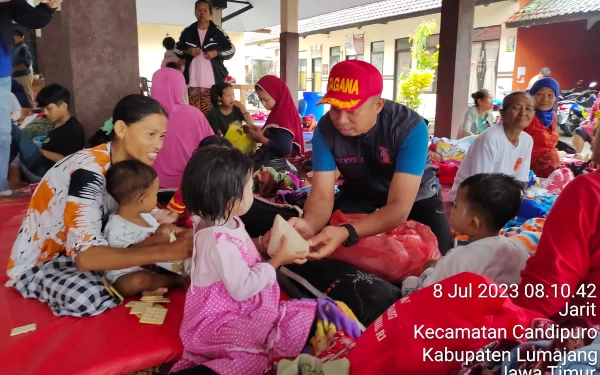 Foto Salah satu tim penyelamat saat membagikan makanan kepada para pengungsi. (Foto: Humas Pemprov Jatim)