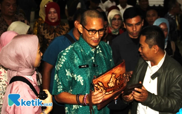 Foto Pengusaha tas kulit ukir asal Tanggulangin, Junaidi, menjelaskan sekilas produknya yang sudah terjual hingga ke Belanda kepada Sandiaga Uno. (Foto: Fathur Roziq/Ketik.co.id)