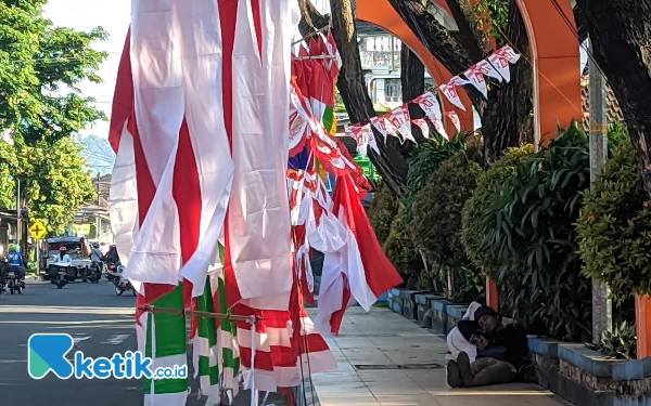 Foto Potret pedagang tengah menunggu hingg ngantuk, lantaran umbul-umbulnya tak banyak yang melirik. (Foto: Al Ahmadi/Ketik.co.id)