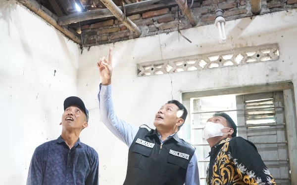 Foto Wakil Bupati Sidoarjo Subandi menunjukkan kerusakan plafon dan atap rumah Mbah Mianah yang sudah rusak parah di Desa Bendotretek, Kecamatan Prambon. Berbahaya bila musim hujan datang. Subandi minta segera ada perbaikan. (Foto: Dinas Kominfo Sidoarjo).