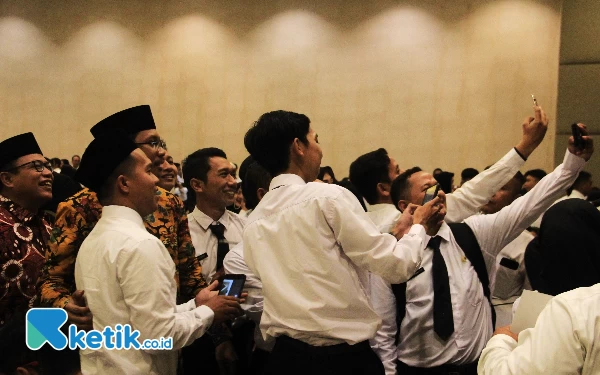 Foto H Usman (kiri) dan Gus Muhdlor melayani dengan sabar setiap permintaan PPPK untuk berfoto bersama setelah prosesi penyerahan SK PPPK di Convention Hall Suncity pada Rabu (9//8/2023). (Foto: Fathur Roziq/Ketik.co.id)