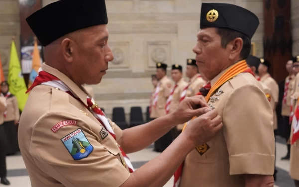 Foto HM Arum Sabil sematkan Lencana Pancawarsa ke salah satu tokoh pramuka. (Foto: Dok. Pramuka)