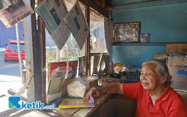 Foto Emi saat menjual koran di lapaknya di Pasar Blimbing (foto: Lutfia/ketik.co.id)