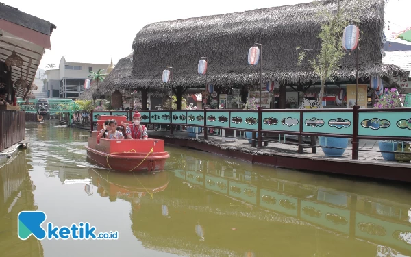 Foto Pengunjung sedang menikmati berkeliling Pasar Apung Museum Angkut dengan menaiki perahu, Sabtu (9/9/2023). (Foto: Sholeh/ketik.co.id)