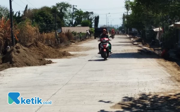 Foto Pengendara sepeda motor dengan enak melaju di atas jalan beton yang membentang di Desa Krembung hingga Mojoruntut pada Kamis (5/10/2023). (Foto: Fathur Roziq/Ketik.co.id)