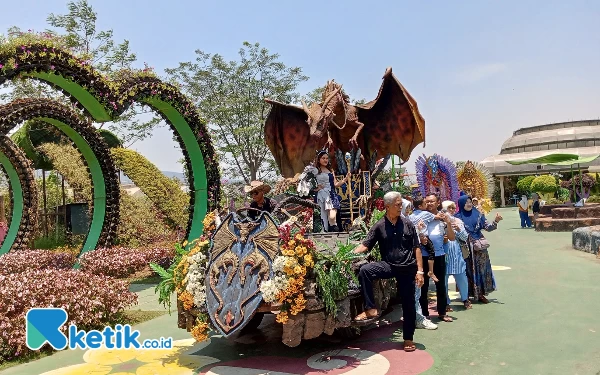 Foto Pengunjung sedang berfoto dengan Peserta Parade Bunga di Baloga Kota Batu, Sabtu (21/10/2023). (Foto: Sholeh/ketik.co.id)