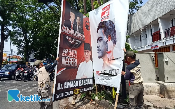 Foto Penertiban reklame milik PSI dan PDI-P di kawasan perempatan Lapangan Rampal. (Foto: Lutfia/Ketik.co.id)