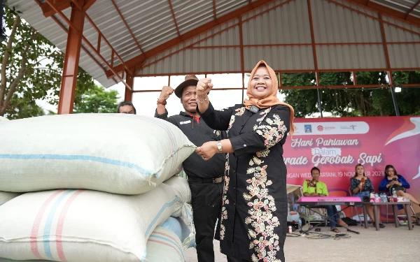 Foto Secara simbolis Bupati Sleman Kustini memberikan bantuan pakan ternak bagi komunitas paguyuban gerobak sapi. (Foto: Humas Pemkab Sleman)