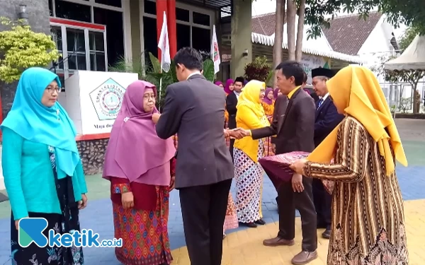 Foto Kepala SMKN 1 Rejotangan Drs. Masrur Hanafi, M.M., saat memberikan selamat kepada Ke sembilan guru penerima penghargaan Satya Lencana Karya Satya saat peringati Hari Guru Nasional ke 78 Tahun 2023.