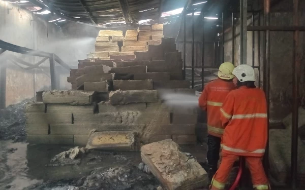 Foto Pemadam kebakaran berusaha melakukan pembasahan agar tidak merembet ke barang lainnya, Senin (27/11/2023). (Foto: Pemadam Kebakaran Surabaya)