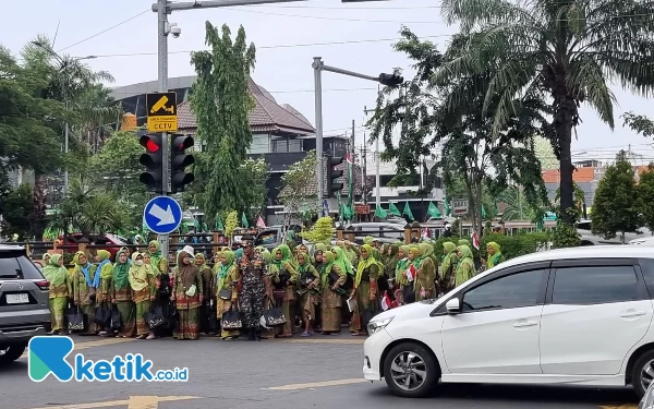 Foto Rombongan Muslimat ini hendak menyebrang Jalan Ahmad Yani untuk ke Jatim Expo, Kamis (7/12/2023). (Foto: Naufal/Ketik.co.id)