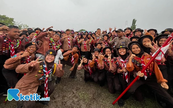 Foto Ketua Kwarda Arum Sabil dan Wali Kota Mojokerto Ika Puspitasari (Kamabicab) foto bersama saat hujan-hujanan bareng peserta. (Foto: Naufal/Ketik.co.id)