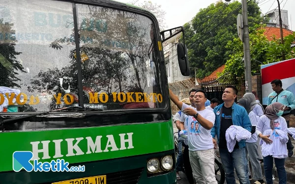 Foto Bus lokal berhenti dan antusias menerima nasi kotak gratis serta kaus Prabowo-Gibran. (Foto: Naufal/Ketik.co.id)