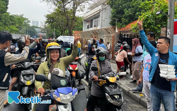 Foto Pengendara motor menunjukkan salam dua jari sebagai wujud dukungan kepada Prabowo-Gibran. (Foto: Naufal/Ketik.co.id)