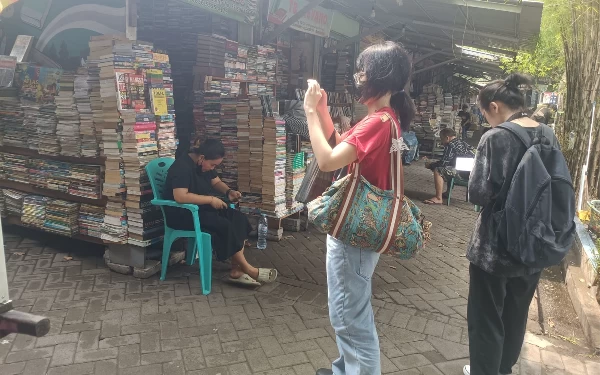 Foto Mahasiswa Universitas Katolik Widya Mandala sedang menjepret stand buku di Kampung Ilmu, Surabaya. (Foto : Ara for Ketik.co.id)