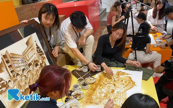 Foto Proses melukis persatuan dan perdamaian dari ampas kopi. (Foto: Shinta Miranda/Ketik.co.id)