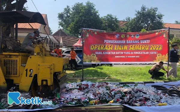 Foto Ribuan botol Miras saat dimusnahkan menggunakan alat berat (Ari Pangistu for ketik.co.id)