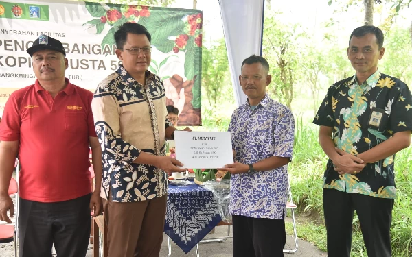 Foto Wabup Sleman Danang Maharsa secara simbolis menyerahkan bantuan berupa fasilitas pengembangan tanaman kopi kepada perwakilan Gabungan Kelompok Tani.(Foto: Humas Pemkab Sleman)