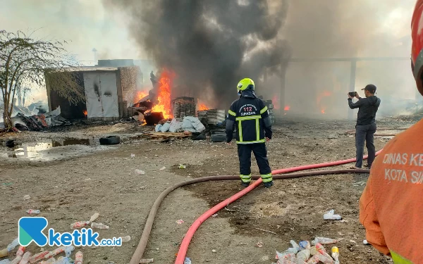 Foto Petugas pemadam kebakaran Surabaya melakukan pemadaman di Gudang Palet, Senin (1/1/2023). (Foto: Khaesar/Ketik.co.id)