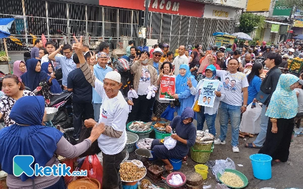 Foto TKD Jatim memberikan dua ribu nasi kotak dan kaos di Pasar Petemon Surabaya, Minggu (7/1/2024). (Foto: Khaesar/Ketik.co.id)