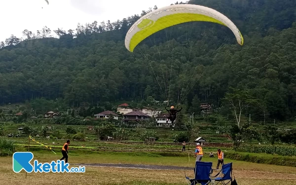 Foto Suasana pendaratan Paralayang di di landing paralayang Lapangan Songgomaruto Kelurahan Songgokerto Kota Batu Jawa Timur. (Foto: Sholeh/ketik.co.id)