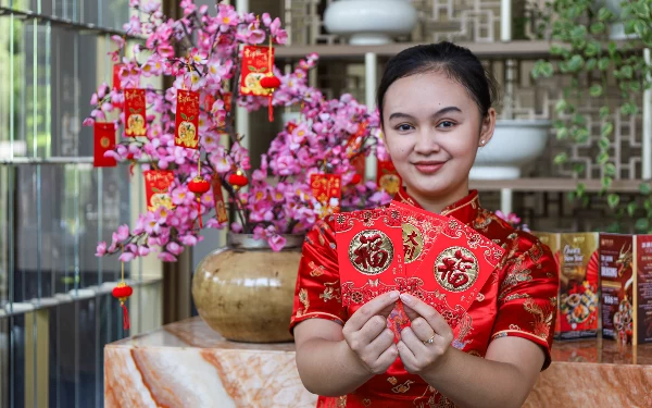 Foto Salah satu staff Ah Yat Abalone Forum Restaurant Malang memegang angpao (Foto: Dok. Ah Yat Abalone)