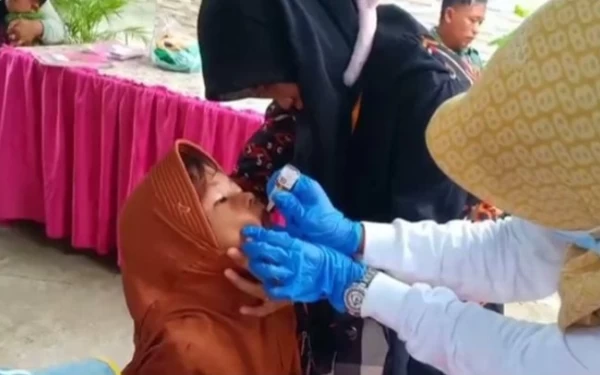 Foto Seorang anak perempuan mendapat imunisasi Polio (Foto: Dok. Puskesmas Klampis, Bangkalan)