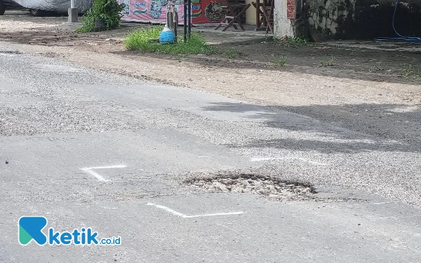 Foto Masyarakat menandai jalan berlubang dengan cat semprot warna putih. (Foto: Fajar Rianto / Ketik.co.id)