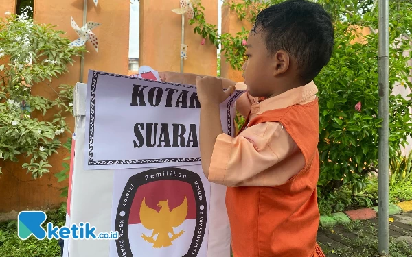 Foto Seorang siswa tengah menaruh surat suara yang sudah dicoblos ke kotak suara yang telah disiapkan (Foto: Shinta Miranda/Ketik.co.id)