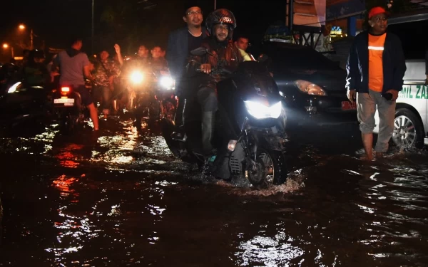 Foto Bupati Gus Muhdlor diboncengkan oleh Camat Tanggulangin Sabino Mariano turun ke lokasi banjir di Desa Kedungbanteng, Kecamatan Tanggulangin pada Sabtu malam (17/2/2024). (Foto: Dinas Kominfo Sidoarjo)