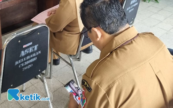 Foto Kadis PUPR Pemkot Malang asyik main hp dan nonton video perempuan berjoget saat Pj Wali Kota Malang sibuk berdialog dengan warga.