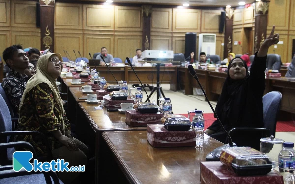 Foto Prini, penyandang tunarungu (kiri) mendengarkan penjelasan dari penerjemah tentang Raperda Perlindungan dan Pemenuhan Hak-Hak Disabilitas saat hearing di DPRD Sidoarjo pada Selasa. (27/2/2024)